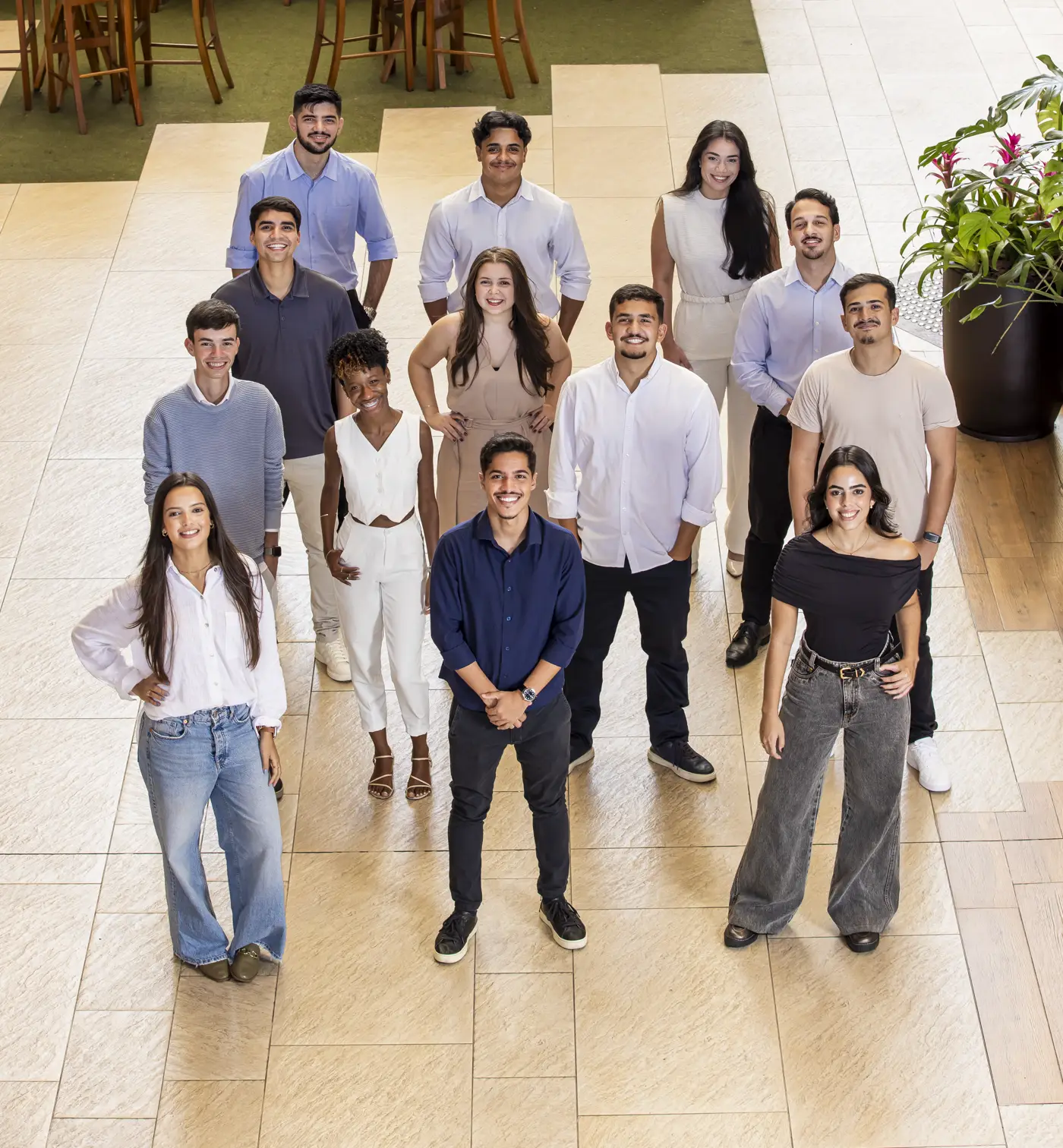 Grupo de jovens estagiários da Multiplan reunidos em um espaço de food court